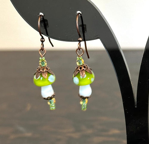 Pair of earrings on a black stand with a neutral background